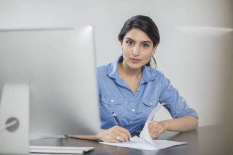 Portrait of businesswoman taking notes at desk in office model released Symbolfoto property released  ZEF15069