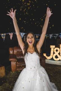Cheerful bride raising her arms while confetti falling over her on a night party outdoors model released Symbolfoto property released  DAPF00954