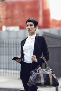 Portrait of fashionable young businesswoman with cell phone and bag model released Symbolfoto  JSMF00061