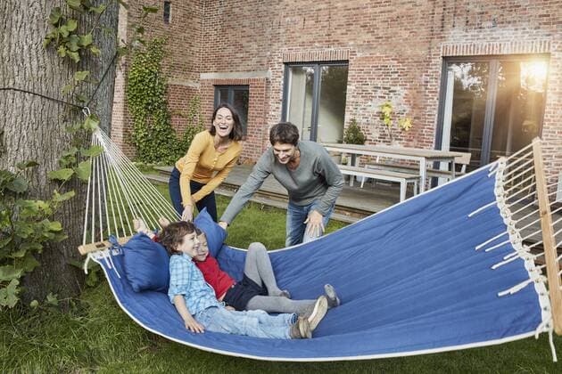 Happy family playing in hammock in garden of their home model released Symbolfoto property released  RORF01217