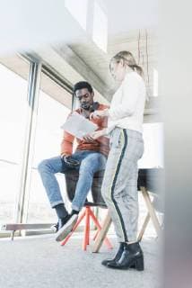 Casual businesswoman and businessman discussing papers in office model released Symbolfoto property released  UUF13109
