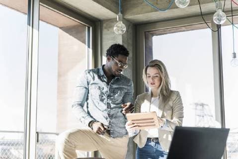 Two colleagues with tablet discussing in office model released Symbolfoto property released  UUF13163