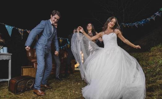 Happy bride dancing and having fun with her friends on a night field party model released Symbolfoto property released  DAPF00940