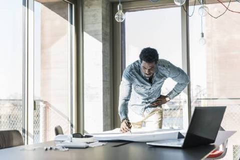 Casual businessman working on plan at table in office model released Symbolfoto property released  UUF13160
