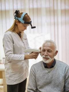 ENT physician examining ear of a senior man model released Symbolfoto property released  ZEDF01235