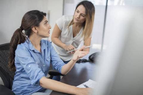 Two businesswomen talking at desk in office model released Symbolfoto property released  ZEF15067