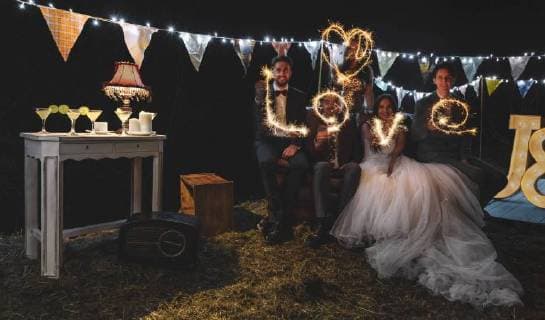 Wedding couple and friends making the word love with sparklers on a night party outdoors model released Symbolfoto property released  DAPF00960