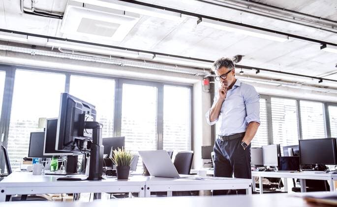 Mature businessman looking at laptop on desk in office model released Symbolfoto property released  HAPF02685