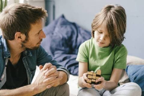 Father looking at son playing with cube a at home model released Symbolfoto property released  KNSF03633