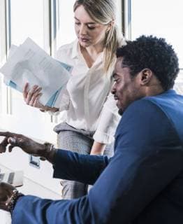 Businesswoman and businessman discussing papers model released Symbolfoto property released  UUF13100