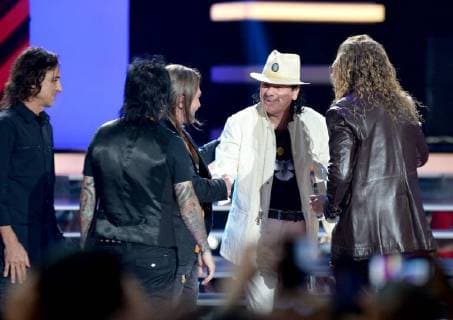 Carlos Santana presents an award to Mana onstage during the 2018 Billboard Latin Music Awards at the Mandalay Bay Events Center in Las Vegas, Nevada on April 26, 2018.  LAV20180426333