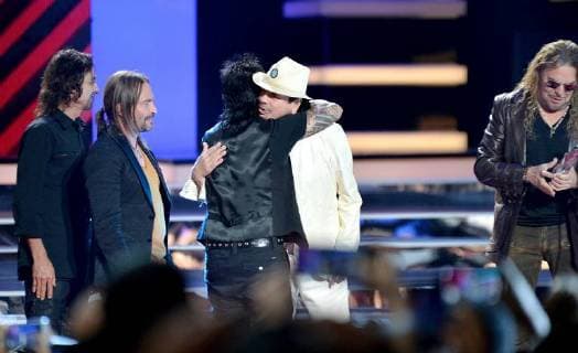 Carlos Santana (C) presents an award to Mana onstage during the 2018 Billboard Latin Music Awards at the Mandalay Bay Events Center in Las Vegas, Nevada on April 26, 2018.  LAV20180426334
