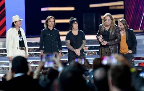 Carlos Santana (L) presents an award to Mana onstage during the 2018 Billboard Latin Music Awards at the Mandalay Bay Events Center in Las Vegas, Nevada on April 26, 2018.  LAV20180426336