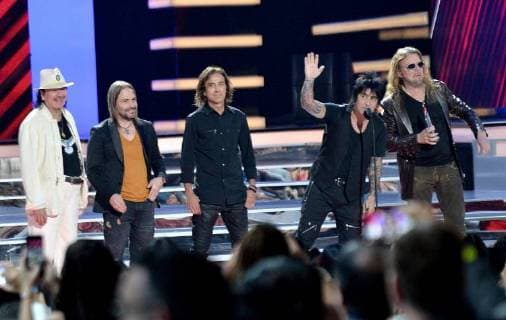 Carlos Santana (L) presents an award to Mana onstage during the 2018 Billboard Latin Music Awards at the Mandalay Bay Events Center in Las Vegas, Nevada on April 26, 2018.  LAV20180426338