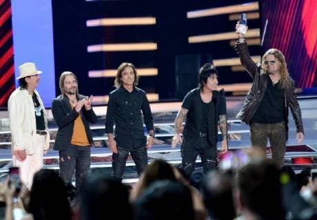 Carlos Santana (L) presents an award to Mana onstage during the 2018 Billboard Latin Music Awards at the Mandalay Bay Events Center in Las Vegas, Nevada on April 26, 2018.  LAV20180426339