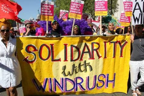 May 5, 2018 - London, England, United Kingdom - Protester hold signs reading Solidarity with the Windrush during a protest in support of the Windrush generation in London, United Kingdom on May 5, 2018. The Windrush generation are people who arrived in the UK after the Second World War from Caribbean countries at the invitation of the British government. It is now thought that an estimated 50,000 people of the Windrush generation face the risk of deportation if they never formalized their residency status and do not have the required documentation to prove it. London United Kingdom  - ZUMAn230 20180505_zaa_n230_1479 Copyright: xAlexxCavendishx