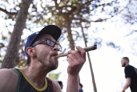 May 5, 2018 - Toronto, Canada - A participant smoking Marijuana stuffed inside a big cigar during the Toronto Global Marijuana march 2018, just a few months before Canada legalizes Marijuana in Toronto, Canada, on May 5, 2018. Toronto Canada  - ZUMAn230 20180505_zaa_n230_1303 Copyright: xArindamxShivaanix