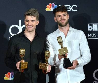 Recording artists Andrew Taggart (L) and Alex Pall of music group The Chainsmokers appear backstage after winning the award for Top Dance Electronic Artist during the 2018 Billboard Music Awards at MGM Grand Garden Arena on May 20, 2018 in Las Vegas, Nevada.  LAV20180520374 JIMxRUYMEN