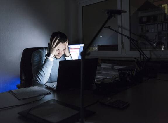 Tired businessman sitting at desk in office at night model released Symbolfoto property released  UUF13220