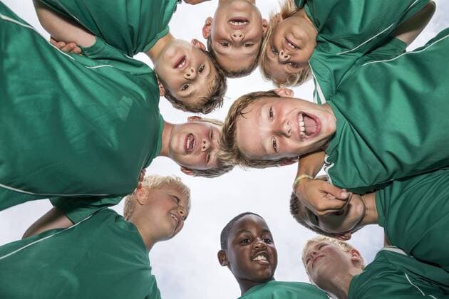 Happy young football players huddling model released Symbolfoto property released  WESTF24035