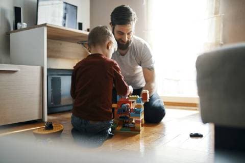 IMAGO Creative: Jahreszeit Winter, Fantasievoll drinnen spielen Father and son sitting on the floor at home playing together with building bricks model released Symbolfoto property released  ZEDF01277