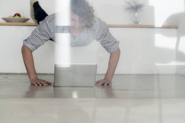 Businessman working from home with his laptop, while doing a plank model released Symbolfoto property released  HHLMF00233