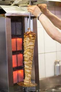 IMAGO Creative, Food, Fast Food, Döner Mensch verschiebt einen Dönerspieß in Richtung der Grillfläche Themenbild, Symbolbild, Döner, Dönerspieß, 29.05.18 Solingen NRW Deutschland DoyDoy *** Human being shifts a doner kebab in the direction of the grill area Themes Icon Döner Dönerspieß 29 05 18 Solingen NRW Germany DoyDoy Copyright: xcdnx
