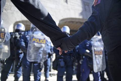 June 9, 2018 - Quebec City, Ontario, Canada - Protesters join hands in front of the riot police during a rally to protest the G7 summit in Quebec City, Canada on 9 June 2018. During the last day of the G7 summit that is happening in La Malbaie, Quebec, protesters came on to the streets to protest the summit in Quebec City. Quebec City Canada  - ZUMAn230 20180609_zaa_n230_1065 Copyright: xArindamxShivaanix