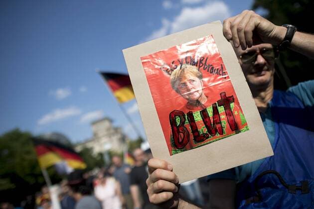 Women s March, Frauenmarsch DEU, Deutschland, Germany, Berlin, 09.06.2018 Demonstrant mit Plakat Asylmissbrauch Blut gegen Angela Merkel auf der Demonstration und sog. Marsch fuer Frauen, Frauenmarsch, organisiert von Mitglieder der rechtspopulistischen Partei AfD, Alternative fuer Deutschland, und Leyla Bilge, Referentin der AfD, unter dem Motto Frauen fuer Freiheit Wir Sind Kein Freiwild Nirgendwo im Regierungsviertel in Berlin. Auf der Demo unter Beteiligung rechter Gruppen und Organisationen demonstrieren Frauen und Maenner nach Angaben der Veranstalter fuer den Schutz deutscher Frauen vor Uebergriffen von Migranten. Hiermit soll ein ein Zusammenhang zwischen sexueller Gewalt und der Zuwanderung von Fluechtlingen und Migranten hergestellt werden. Supporters and Demonstrants with poster against Angela Merkel at a rally of German ri