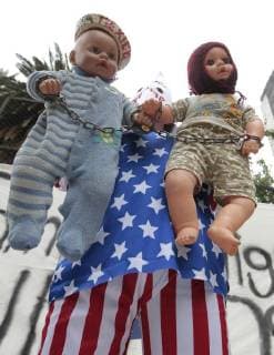 A hooded person holds two dolls during a protest in front of the US Embassy against the policy of separation of migrant families applied by Washington, in Mexico City, Mexico, 21 June 2018. US president Donald J. Trump signed an executive order on 20 June to end the separation of immigrant children from their parents on the border with Mexico. Mexicans protest against separation of immigrant children from their parents on border with US !ACHTUNG: NUR REDAKTIONELLE NUTZUNG!  Copyright: xMARIOxGUZMANx MEX001 20180622-636652366695074352