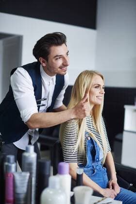 Hairdresser advising his customer model released Symbolfoto property released  ABIF00347