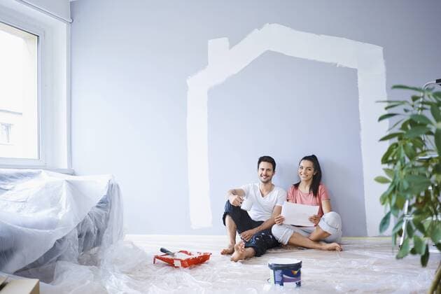 Happy couple taking break from painting walls in new apartment model released Symbolfoto property released  BSZF00425