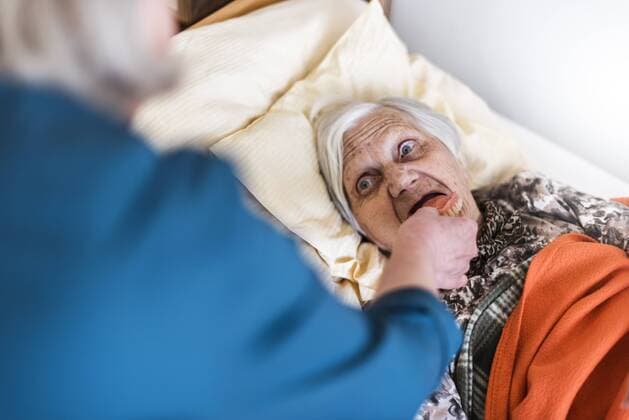 Woman taking care of old woman lying in bed model released Symbolfoto  DIGF04064