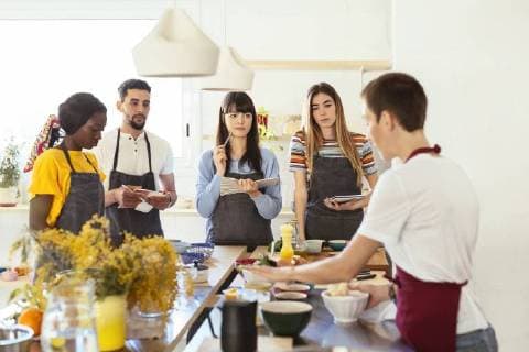 Friends in a cooking workshop listening to instructor model released Symbolfoto property released  EBSF02417