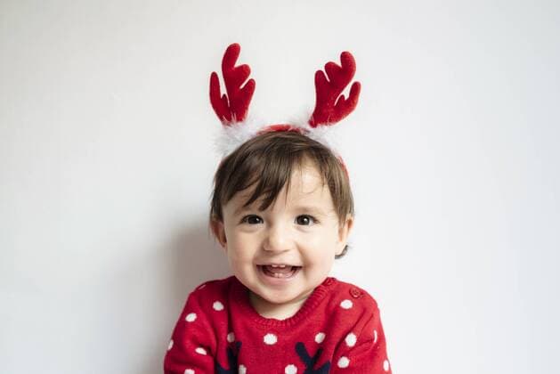 Portrait of laughing baby girl wearing reindeer antlers headband model released Symbolfoto  GEMF01941