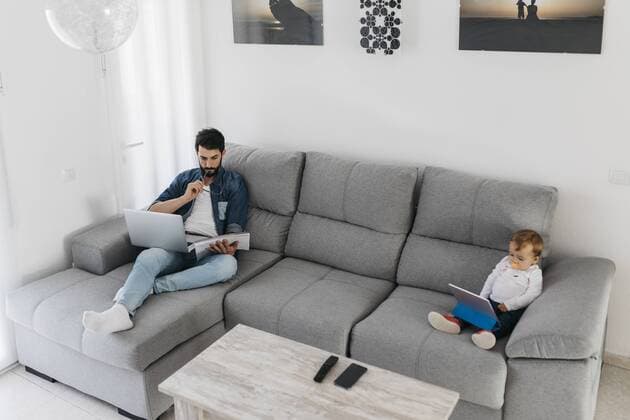 Father working in the living room while the daughter watching the tablet model released Symbolfoto property released  JRFF01657