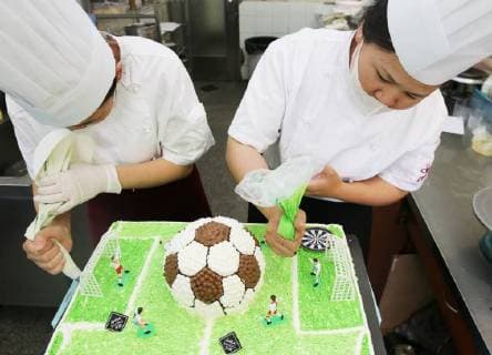 China: Football shaped cake Bakers make a World Cup themed cake at a bakery in Nantong, east China s Jiangsu Province. People can see football and football field at the cake. CHINA OUT Nantong Nantong China  XuxCongjun