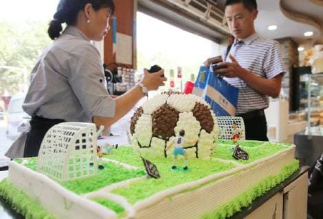 China: Football shaped cake Bakers make a World Cup themed cake at a bakery in Nantong, east China s Jiangsu Province. People can see football and football field at the cake. CHINA OUT Nantong Nantong China  XuxCongjun