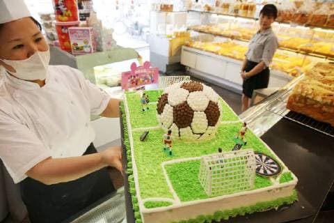 China: Football shaped cake Bakers make a World Cup themed cake at a bakery in Nantong, east China s Jiangsu Province. People can see football and football field at the cake. CHINA OUT Nantong Nantong China  XuxCongjun