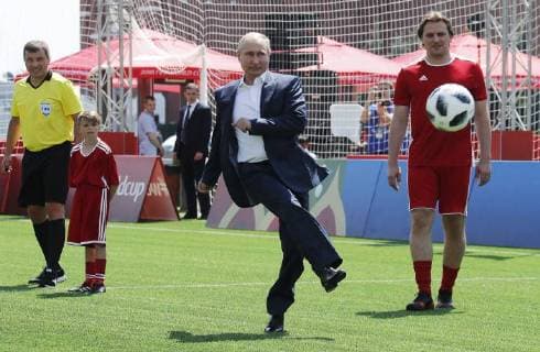 MOSCOW, RUSSIA - JUNE 28, 2018: Russia s President Vladimir Putin (C) kicks the ball as he visits the 2018 FIFA World Cup Football Park in Red Square. Mikhail Metzel TASS  TS086D64
