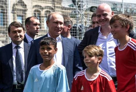 MOSCOW, RUSSIA - JUNE 28, 2018: Adviser to the President of Russia Igor Levitin (L), Russia s President Vladimir Putin (C midground), FIFA President Gianni Infantino (R midground), and young football players visit the 2018 FIFA World Cup Football Park in Red Square. Alexei Nikolsky Russian Presidential Press and Information Office TASS  TS086D82