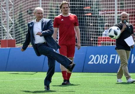 MOSCOW, RUSSIA - JUNE 28, 2018: Russia s President Vladimir Putin (L) kicks the ball as Russian football player Dmitry Bulkin (C) looks on as they visit the 2018 FIFA World Cup Football Park in Red Square. Alexei Nikolsky Russian Presidential Press and Information Office TASS  TS086D78