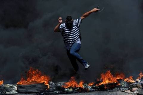 Bilder des Tages June 29, 2018 - Ramallah, West Bank, Palestinian Territory - A masked Palestinian protester jumps up burning tires during clashes with Israeli troops following a demonstration near the Jewish settlement of Beit El, near Ramallah, in the occupied West Bank June 29, 2018 Ramallah Palestinian Territory - ZUMAap3_ 20180629_zaf_ap3_029 Copyright: xShadixHatemx