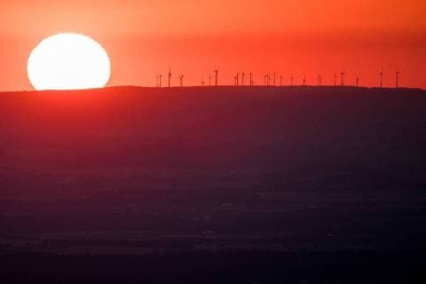 Sunset behind wind farm on the Great Feldberg The sun goes on the evening of 29 06 2018 seen from the Great Feldberg in Taunus behind a wind farm under Schmitten Germany
