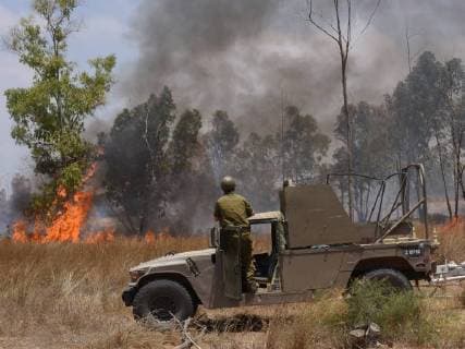 IMAGO Nature: Unsere Erde, Klimawandel, Waldbrände News Bilder des Tages An Israeli soldier watches a forest fire ignited by a kite sent from the Gaza Strip, in the Eshkol Region near the border with Gaza in southern Israel, July 17, 2018. Palestinians from Gaza continue to send burning kites to Israeli territory, causing damage to thousands of acres of nature reserves and agricultures land.  JER2018071708 DEBBIExHILL