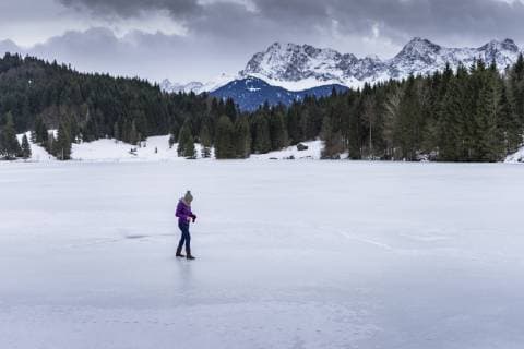 IMAGO Creative: Jahreszeit Winter, Spaziergang Side view of Woman walking on frozen lake in winter in Bavarian Alps, Garmisch-Partenkirchen, Bavaria, Germany, Garmisch-Partenkirchen Bavaria Germany HUTI000012 model released Symbolfoto Copyright: TimmxHumpfer HUTI000012