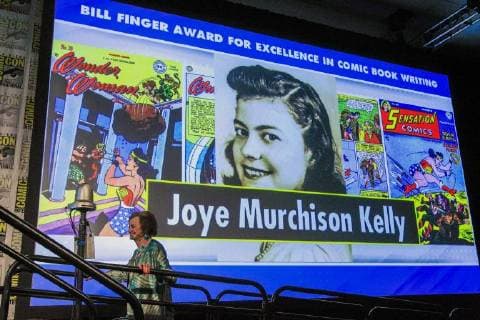 July 20, 2018 - San Diego, CA, USA - SAN DIEGO, July 20, 2018 Joye Murchison Kelly, 94, ghost writer of Wonder Woman walks past a projection with a picture of her as a younger woman as she walks up on stage to receive her Bill Finger Award for Excellence in Comic Book Writing during the Will Eisner Comic Industry Awards ceremony at the Hilton Bayfront in San Diego on Friday. Hayne Palmour IV San Diego Union-Tribune Mandatory Credit: HAYNE PALMOUR IV SAN DIEGO UNION-TRIBUNE ZUMA PRESS San Diego Union-Tribune Hayne Palmour IV copyright 2018 San Diego USA - ZUMAs44_ 20180720_zaf_s44_061 Copyright: xHaynexPalmourxIvx