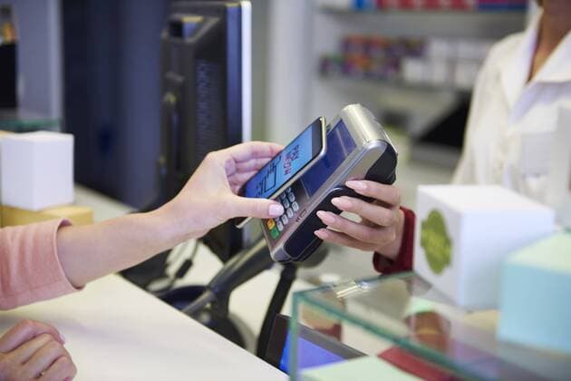 Customer paying cashless with smartphone in a pharmacy model released Symbolfoto property released  ABIF00400