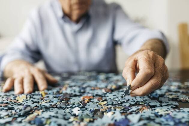 Senior man doing a jigsaw model released Symbolfoto property released  JRFF01676