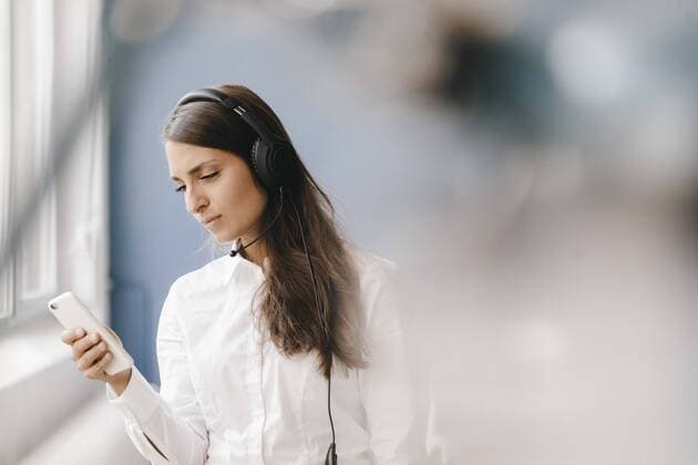 Young woman using smartphone, wearing headset model released Symbolfoto property released  KNSF03914